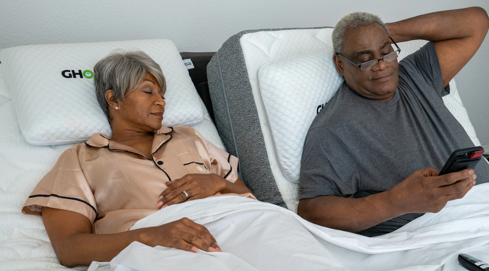An elderly couple relaxes on their GhostBed Adjustable Base.