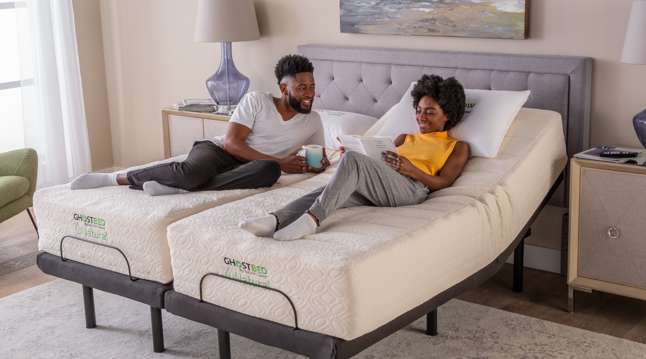 A couple relaxes on their Split King Adjustable Base with GhostBed Natural mattresses.