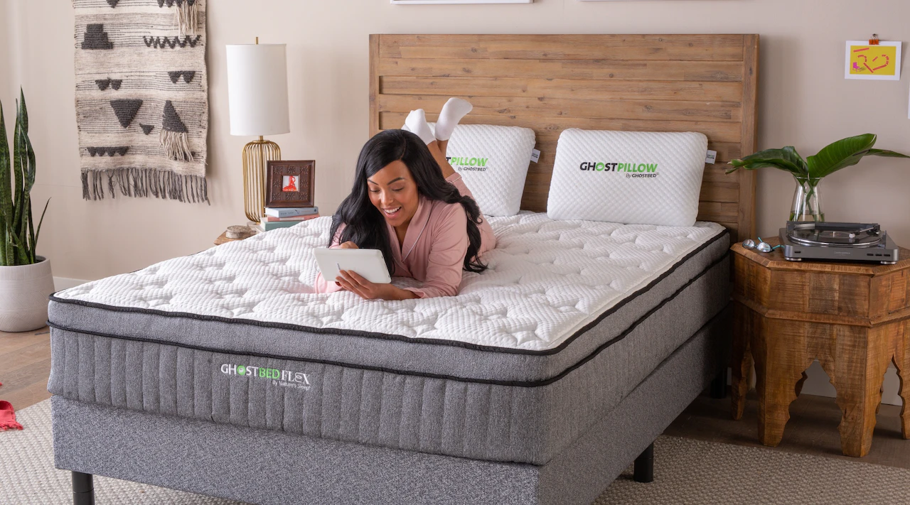 A woman relaxes on a GhostBed Flex hybrid mattress