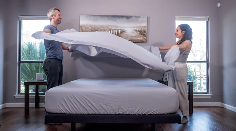 Couple replacing grey GhostBed sheets after cleaning