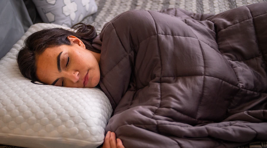 Woman sleeping with a GhostBed weighted blanket